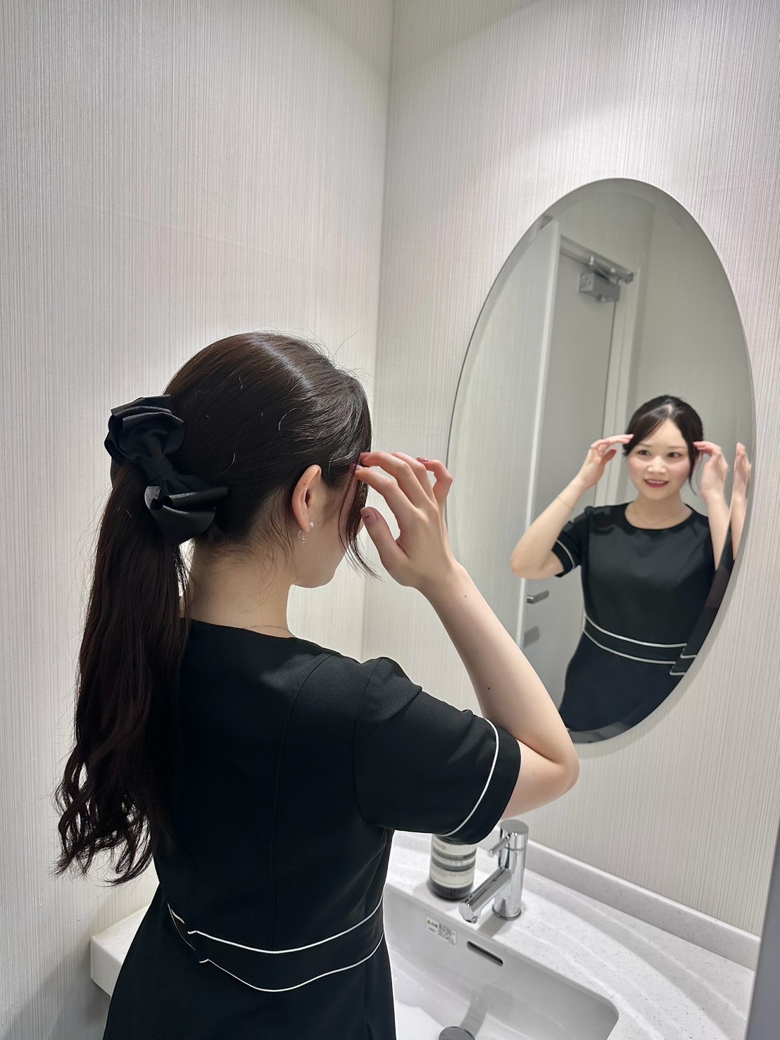 鏡の前で身だしなみを整えるスタッフ